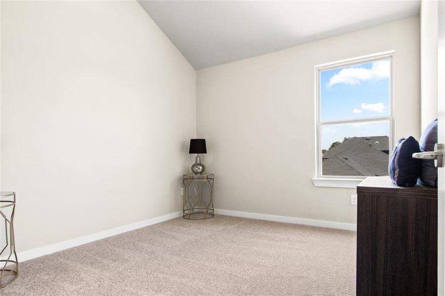 Carpeted empty room featuring vaulted ceiling