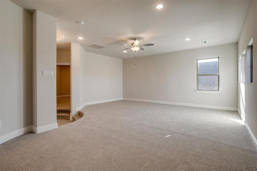 Carpeted empty room with ceiling fan