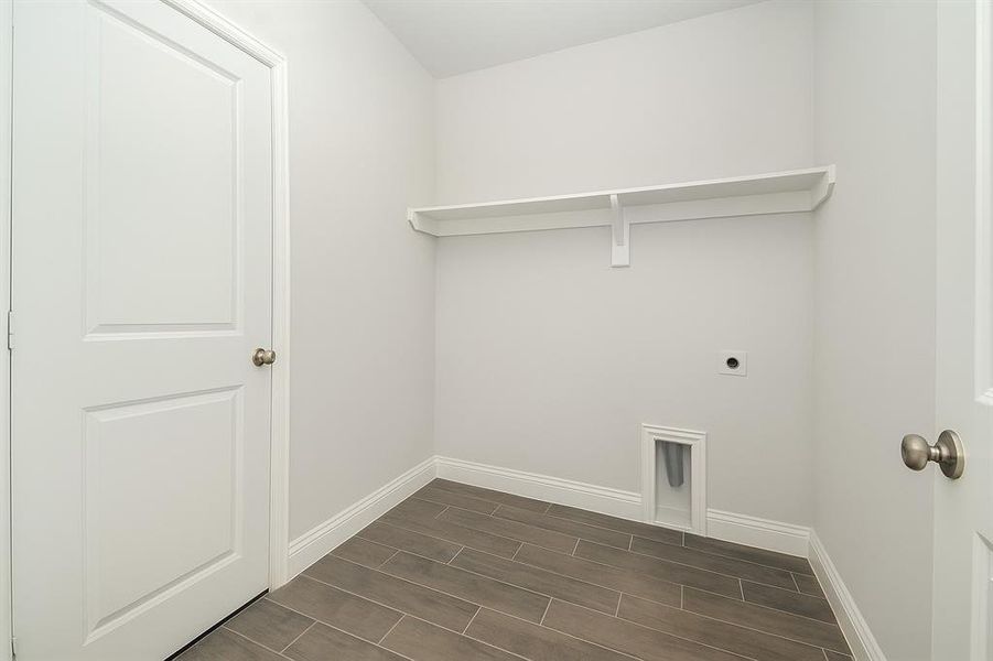 Laundry room with electric dryer hookup and wood tiled floors Laundry room with electric dryer hookup and wood tiled floors