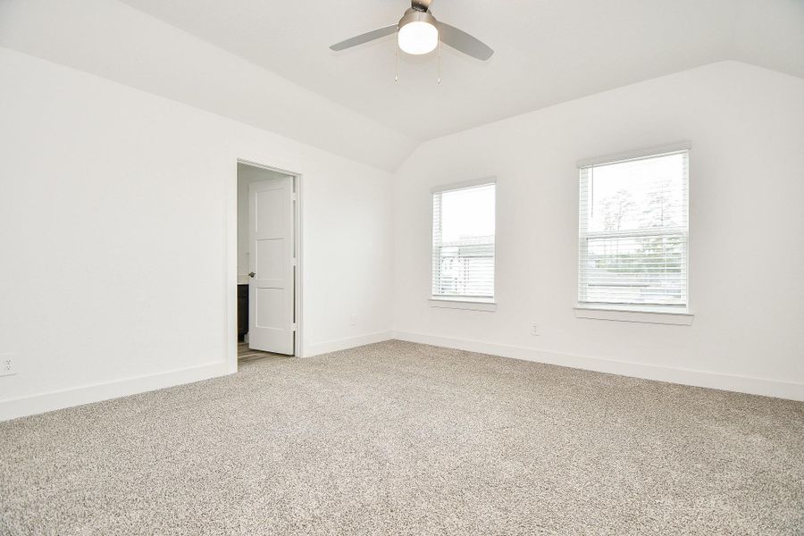 Bright and spacious second primary bedroom with neutral carpet, two large windows, and a ceiling fan. Located on the second floor, it connects to a private bath and walk-in closet, offering a clean and modern ambiance. Bright and spacious second primary bedroom with neutral carpet, two large windows, and a ceiling fan. Located on the second floor, it connects to a private bath and walk-in closet, offering a clean and modern ambiance.