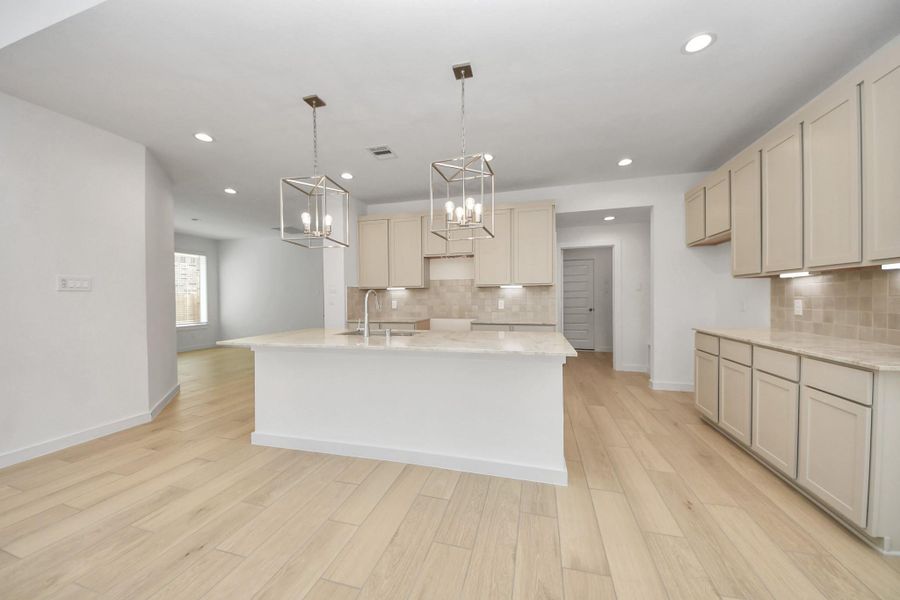Discover another perspective of this stunning kitchen, generously appointed with an abundance of counter space. Sample photo of completed home with similar floor plan. Actual colors and selections may vary.