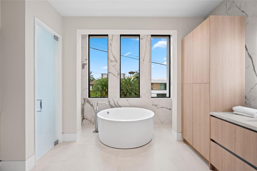 Spa-inspired bathroom with bright windows and a modern freestanding soaking tub. Spa-inspired bathroom with bright windows and a modern freestanding soaking tub.