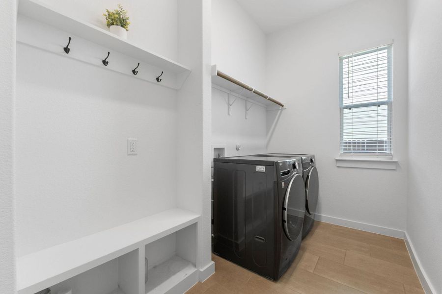 Washroom featuring baseboards, independent washer and dryer, light wood-style flooring, and laundry area