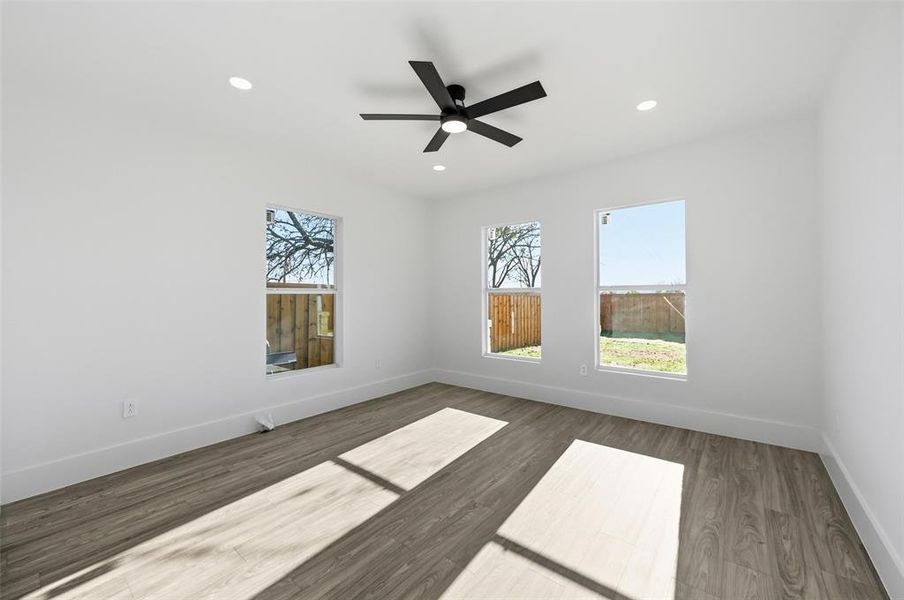 Spare room featuring wood finished floors, plenty of natural light, recessed lighting, and a ceiling fan Spare room featuring wood finished floors, plenty of natural light, recessed lighting, and a ceiling fan