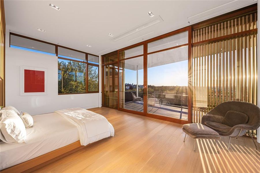 Primary bedroom with floor to ceiling windows and private balcony.