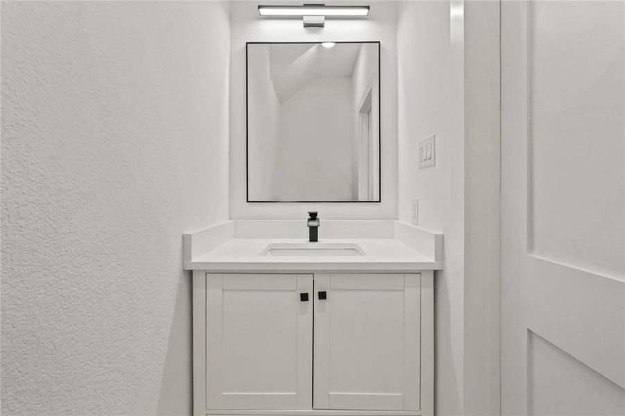 Bathroom featuring vanity and a textured wall