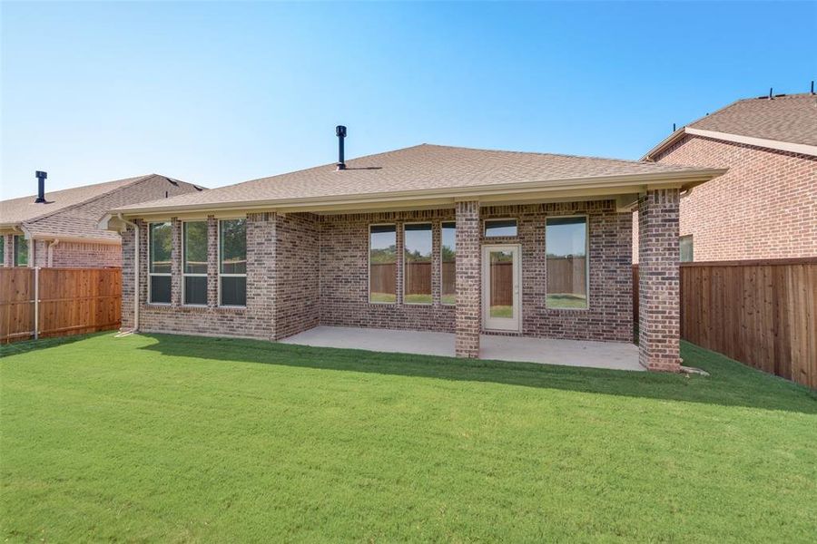 Rear view of house with a lawn and a patio area