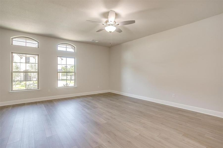 Spare room featuring light wood-style floors and a ceiling fan Spare room featuring light wood-style floors and a ceiling fan