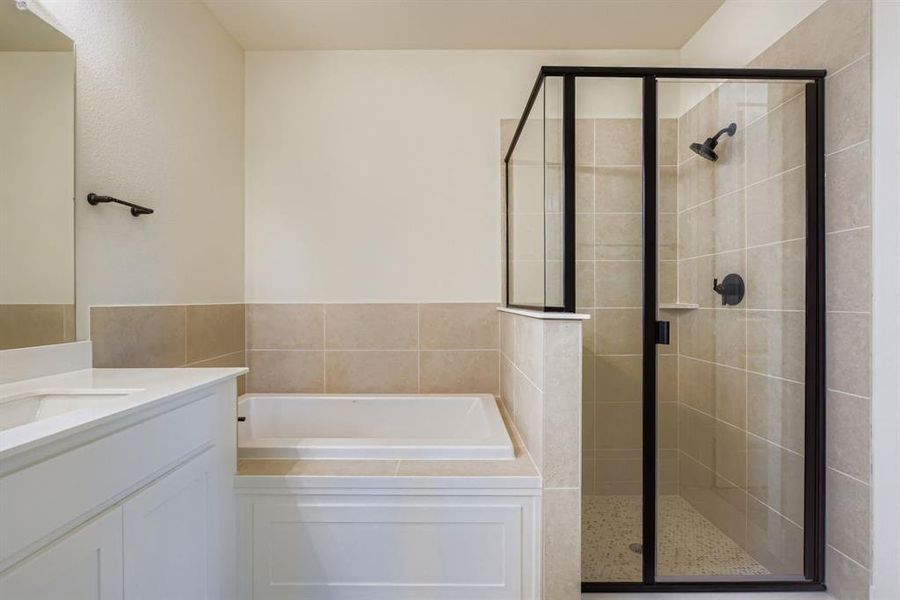 Full bathroom featuring a bath, vanity, and a shower stall