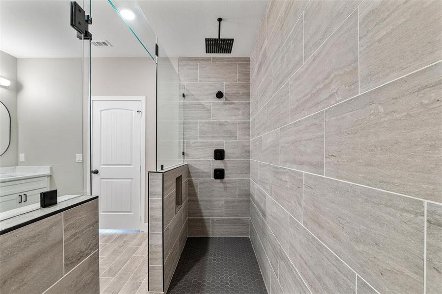 Bathroom with vanity, hardwood / wood-style floors, and a tile shower