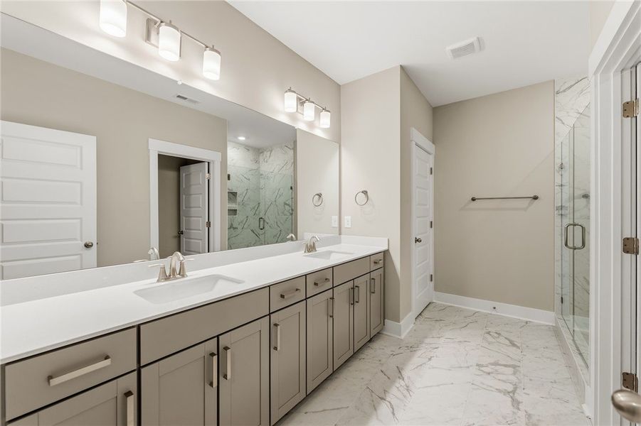 Marble-look tile flooring and a dual-sink vanity c