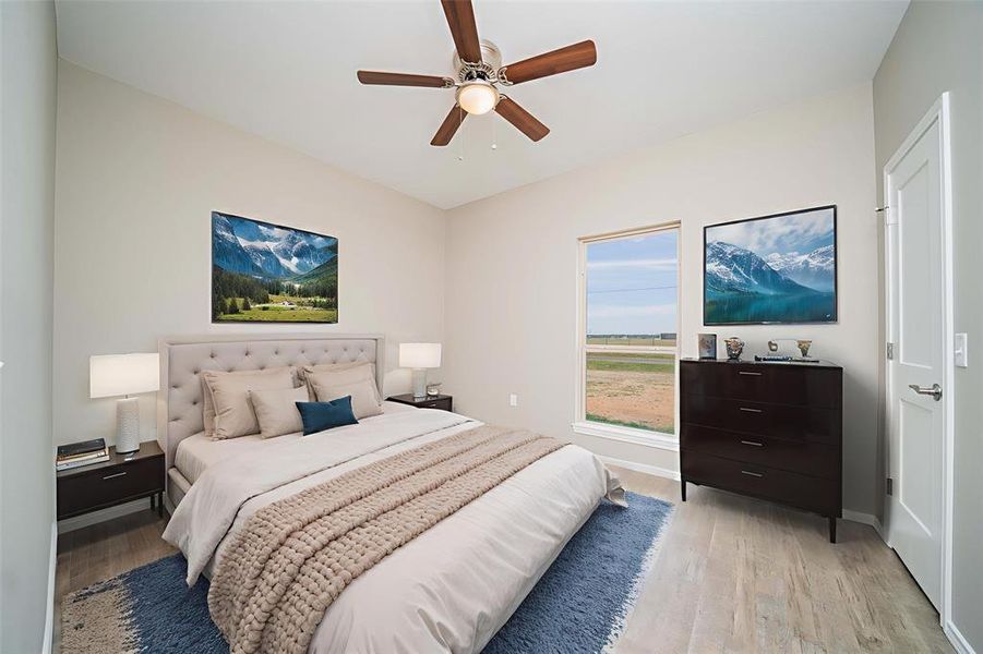 Bedroom with light wood finished floors and ceiling fan Bedroom with light wood finished floors and ceiling fan