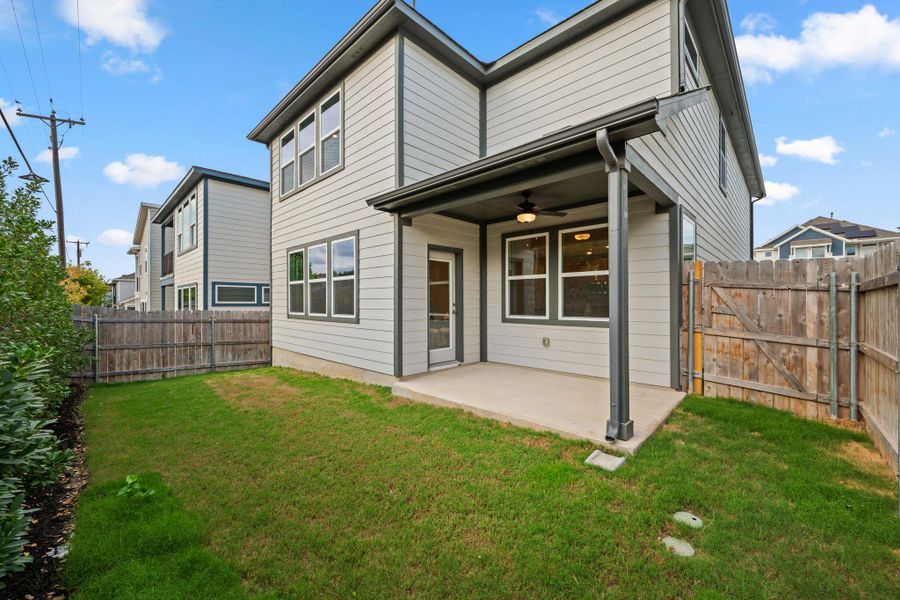 Fully fenced backyard with grass.