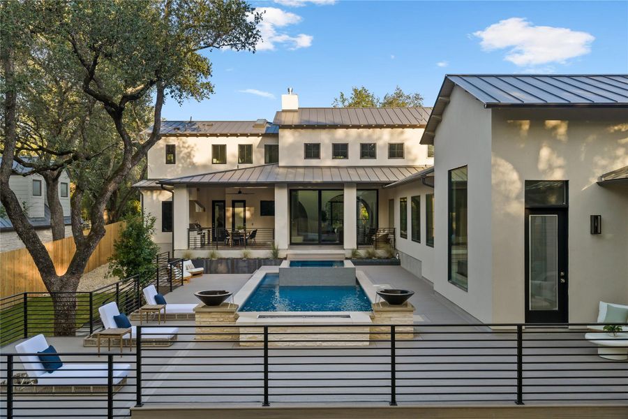 An inviting tiered outdoor living area boasts a sparkling pool, spa, and ample space for entertaining.