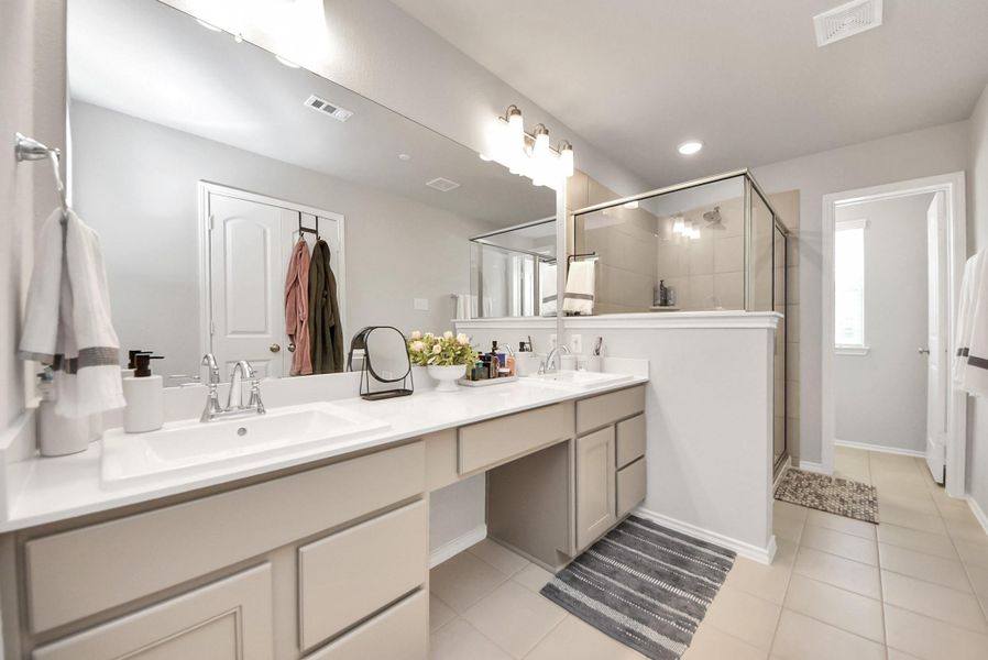 Beautiful primary bath room with so much space. Note the vanity area plus dual sinks along with lots of storage space. Large walk-in shower on the left and toilet room with window in the distance. Beautiful primary bath room with so much space. Note the vanity area plus dual sinks along with lots of storage space. Large walk-in shower on the left and toilet room with window in the distance.