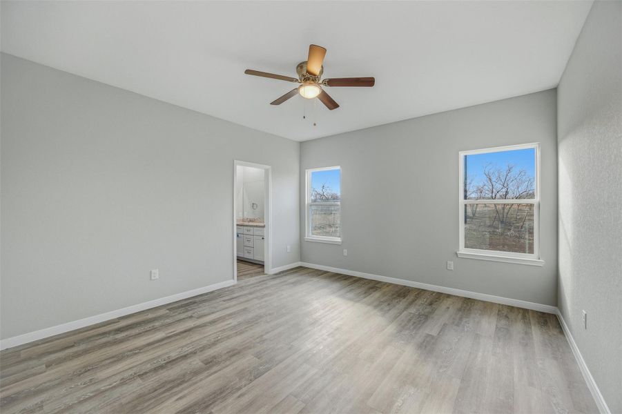 A tranquil bedroom space featuring modern flooring and a refreshing view of the outdoors.