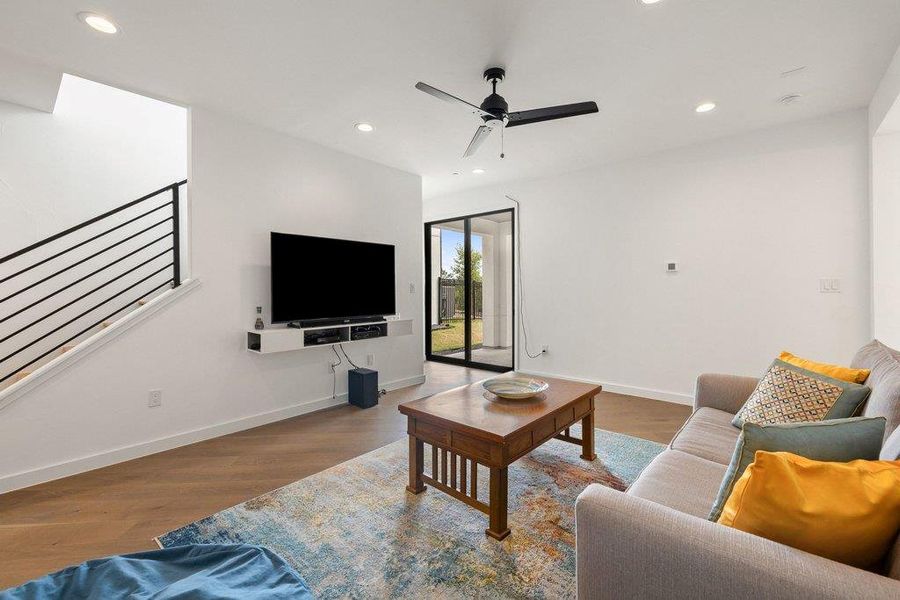 Living area featuring wood-finish flooring, recessed lighting, and a black ceiling fan