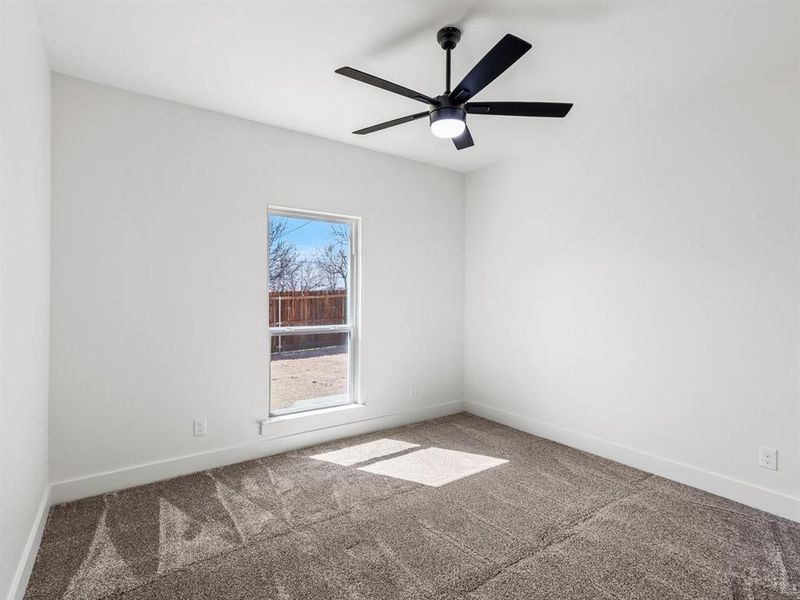 Unfurnished room with baseboards, ceiling fan, and carpet flooring