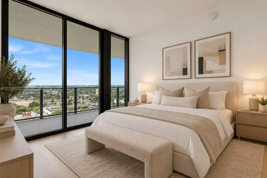 Floor-to-ceiling black-framed glass sliding doors, private balcony, wood-finish flooring, and expansive natural light