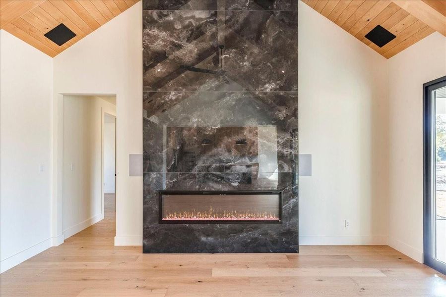 A floor-to-ceiling 72" black porcelain wall with an electric fireplace enhances the room's elegance.