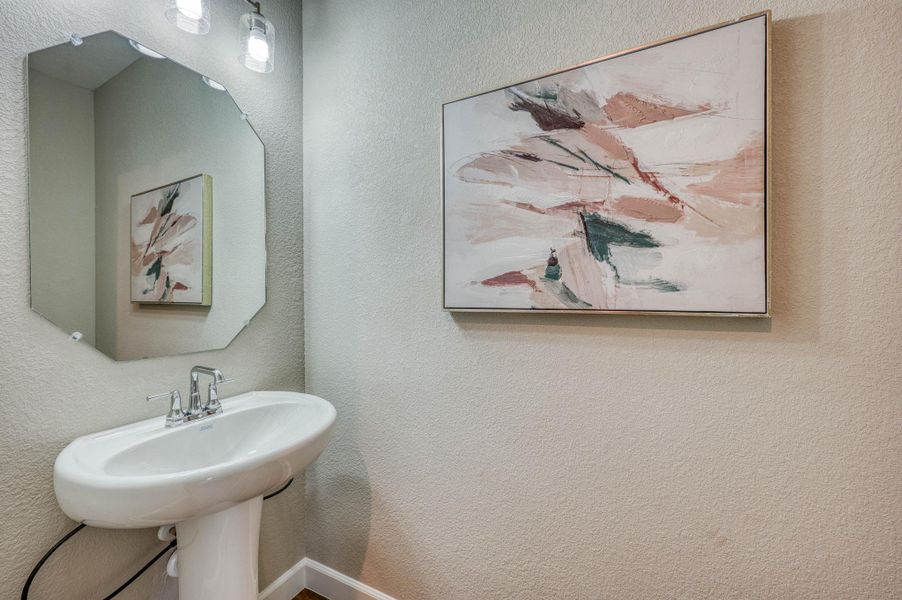 A classic pedestal sink pairs with textured walls in this elegant powder room. A classic pedestal sink pairs with textured walls in this elegant powder room.