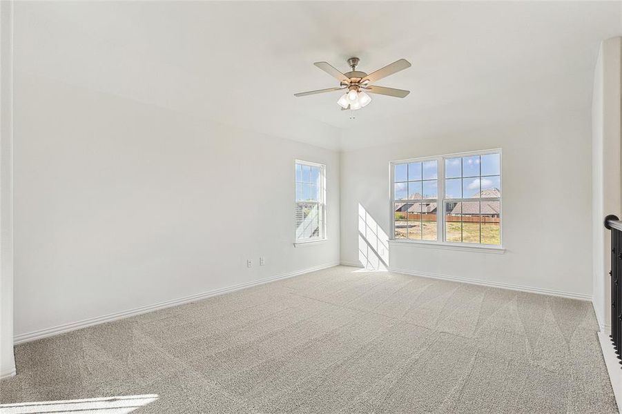 Carpeted spare room featuring ceiling fan