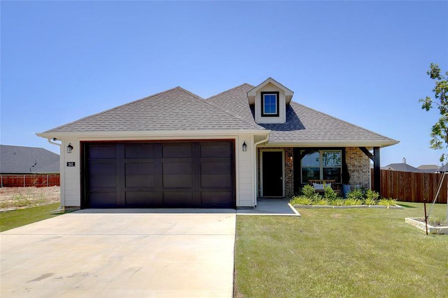 View of front facade featuring a front lawn and a garage