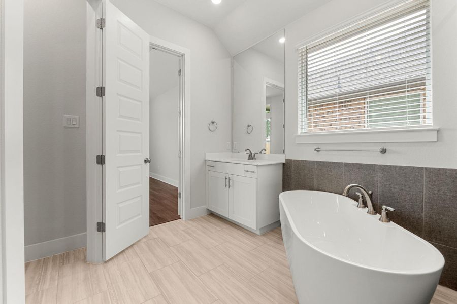 Full bath featuring a soaking tub and vanity Full bath featuring a soaking tub and vanity