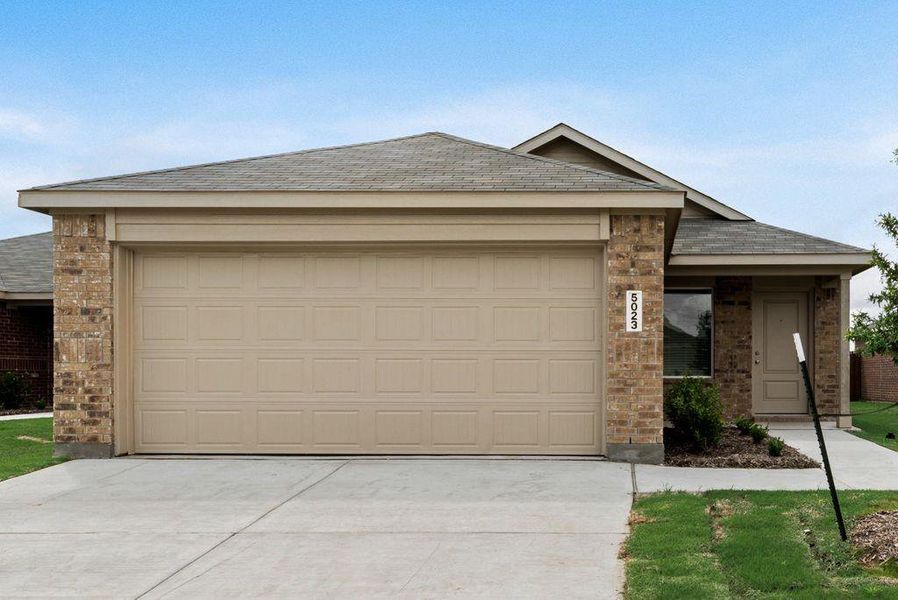 Single story home featuring brick siding, a shingled roof, driveway, and an attached garage