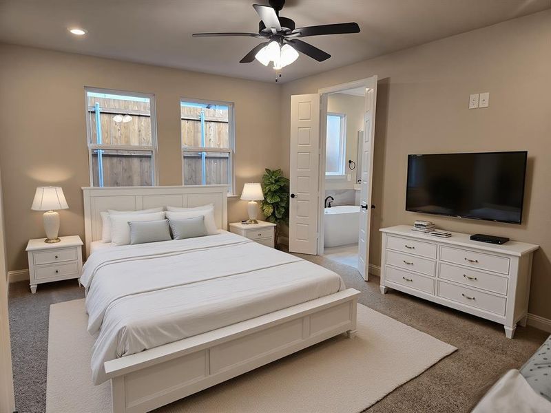 Bedroom featuring light colored carpet, a ceiling fan, and ensuite bathroom Bedroom featuring light colored carpet, a ceiling fan, and ensuite bathroom