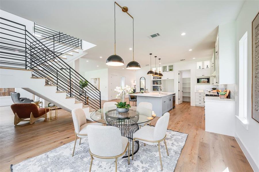 Dining area featuring stairs, recessed lighting, and light wood-type flooring Dining area featuring stairs, recessed lighting, and light wood-type flooring