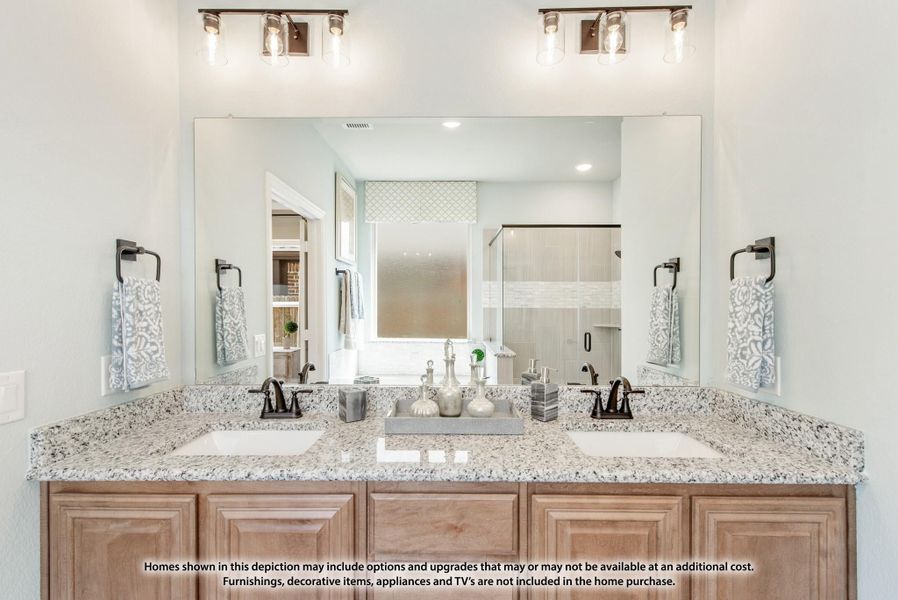 Bathroom double vanity with granite countertop, wood cabinets, large mirror, and industrial-style light fixtures above two sinks Bathroom double vanity with granite countertop, wood cabinets, large mirror, and industrial-style light fixtures above two sinks