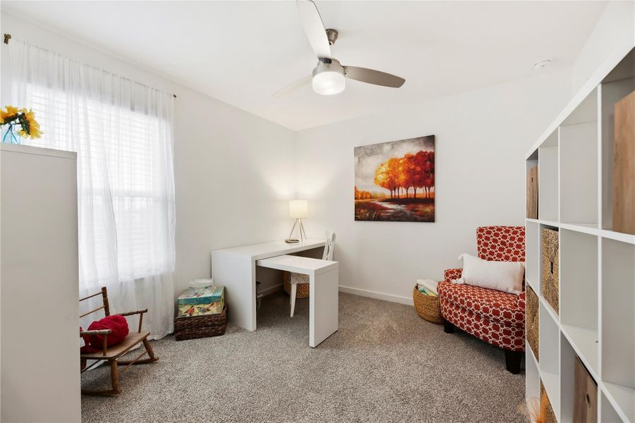 Upstairs bedroom with carpet, ceiling fan, window and a walk-in closet.