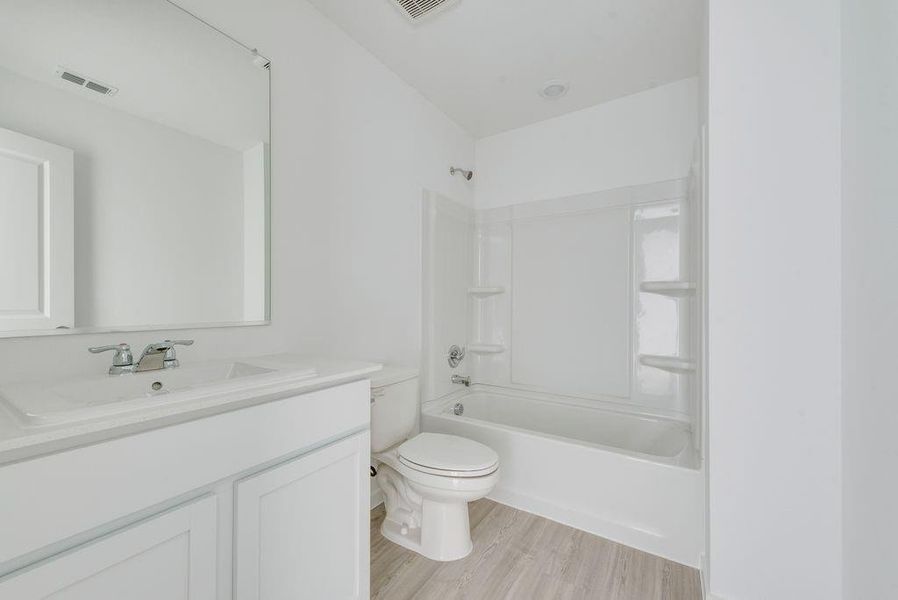 Bathroom with vanity,  shower combination, and light wood-type flooring