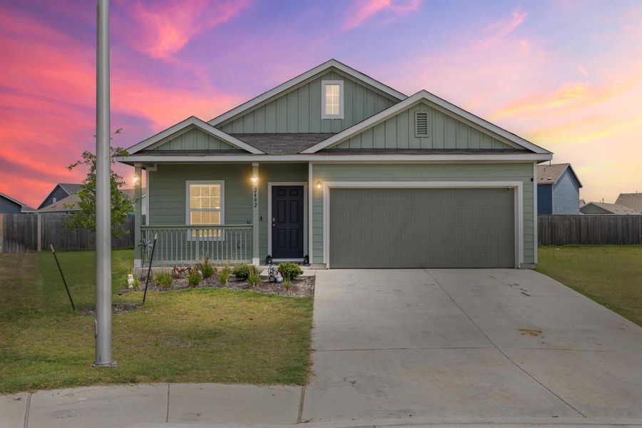View of front of home with a porch, concrete driveway, an attached garage, and board and batten siding View of front of home with a porch, concrete driveway, an attached garage, and board and batten siding