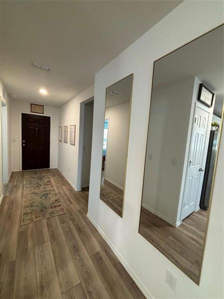 Hallway featuring wood finished floors and baseboards