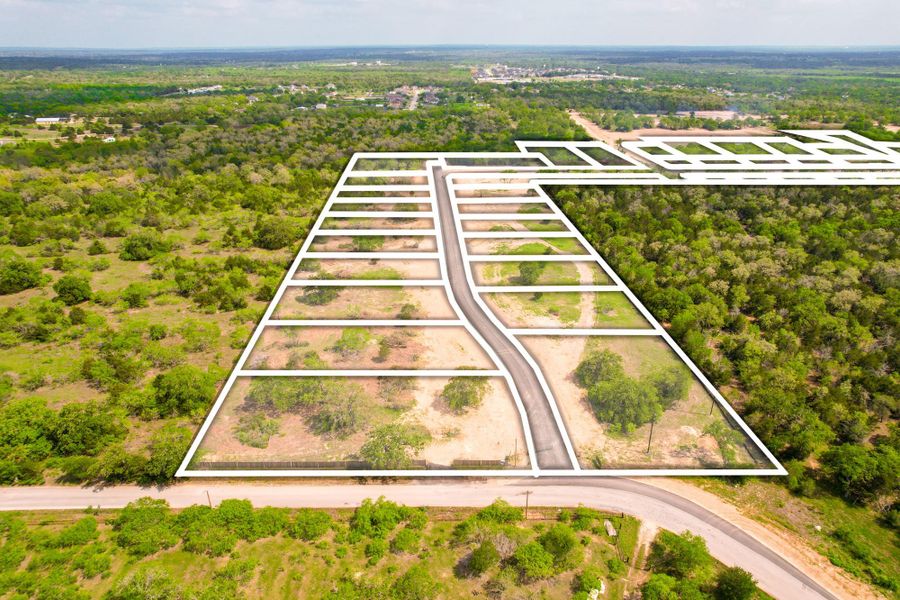 Prime acreage with designated lots and road access for new development, surrounded by verdant landscapes.