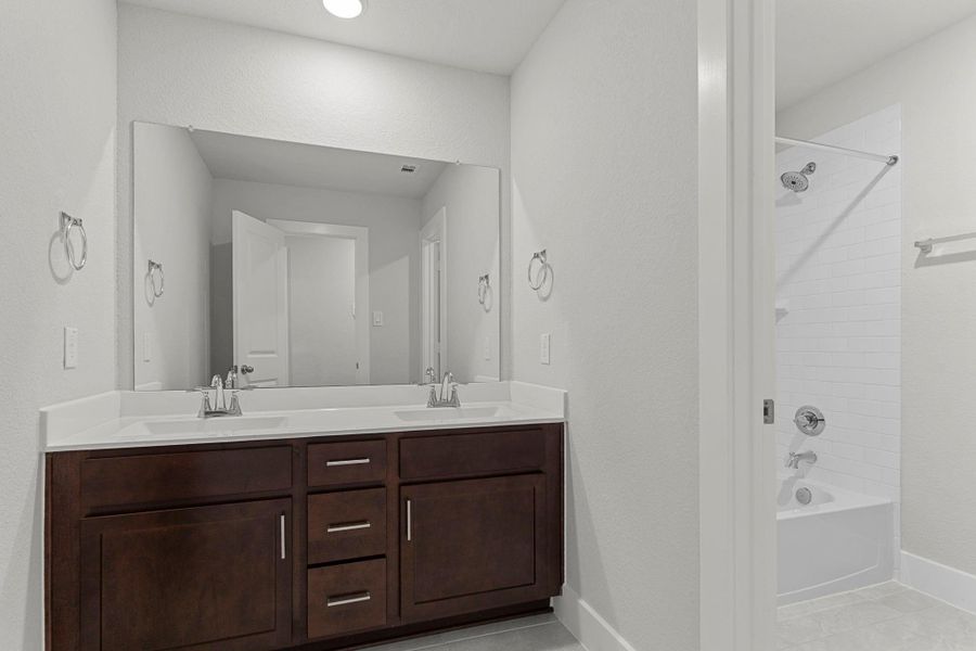 The secondary bath features dual sinks, sleek fixtures, and a full tub/shower combination, providing plenty of space for shared use while maintaining a fresh and modern look. The secondary bath features dual sinks, sleek fixtures, and a full tub/shower combination, providing plenty of space for shared use while maintaining a fresh and modern look.
