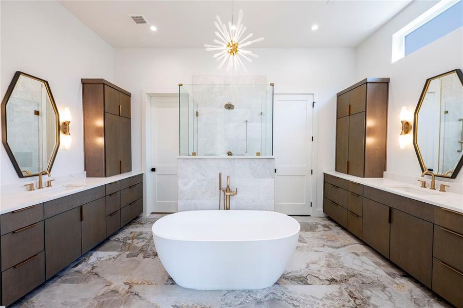 Bathroom featuring vanity, an inviting chandelier, and plus walk in shower