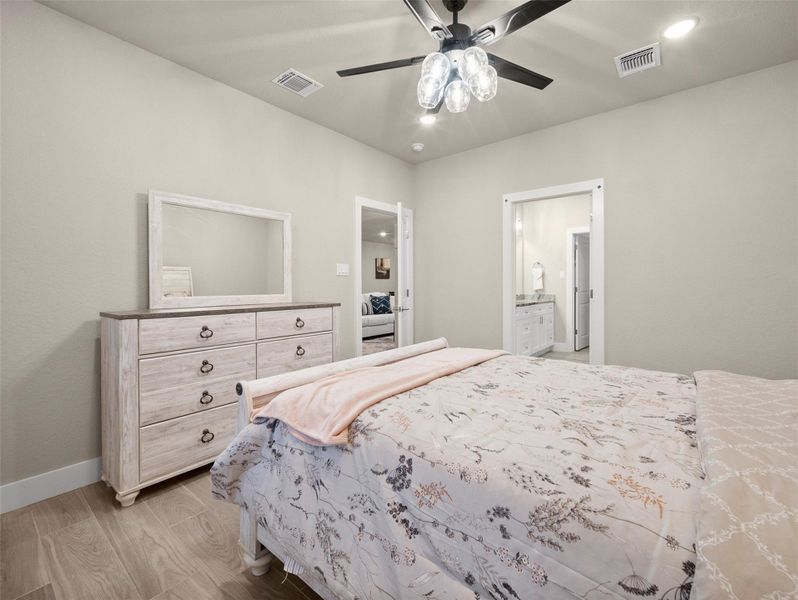 Bedroom with light wood-style flooring, recessed lighting, ceiling fan, and ensuite bathroom Bedroom with light wood-style flooring, recessed lighting, ceiling fan, and ensuite bathroom