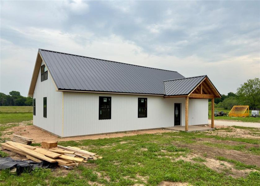 View of front facade featuring a metal roof and a patio area