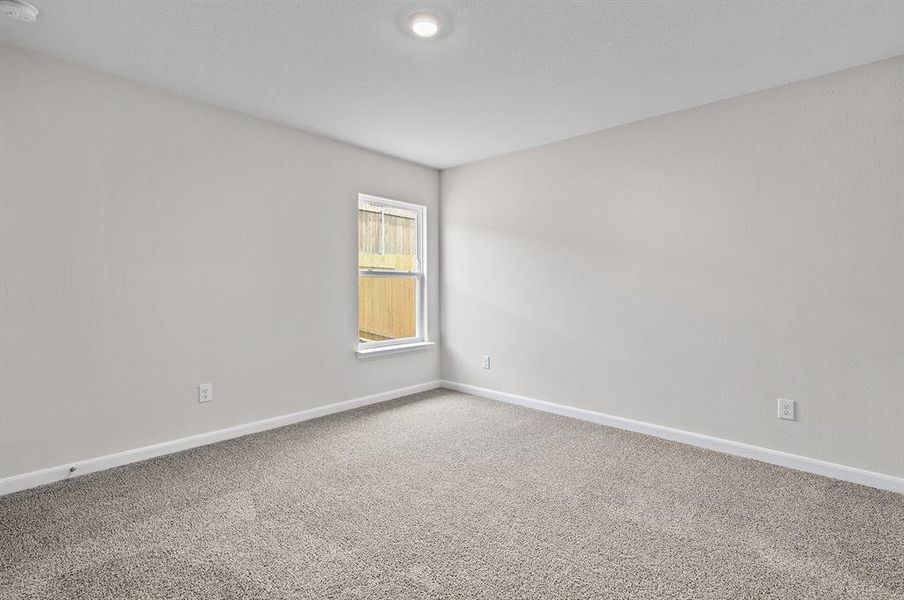 Carpeted spare room featuring baseboards