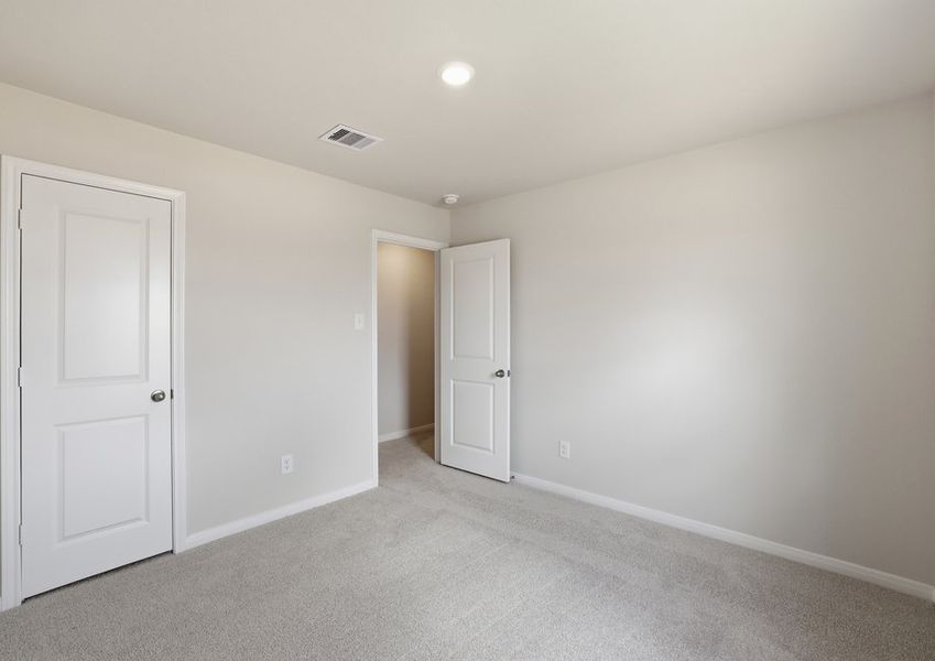 Carpeted secondary bedroom featuring a closet door and neutral wall color.