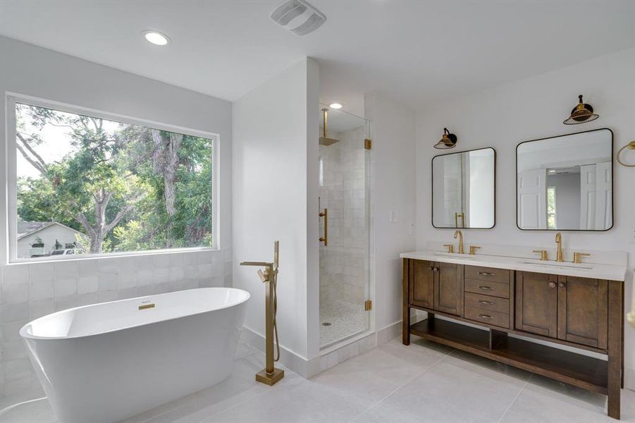 Bathroom featuring tile walls, tile patterned flooring, separate shower and tub, and vanity