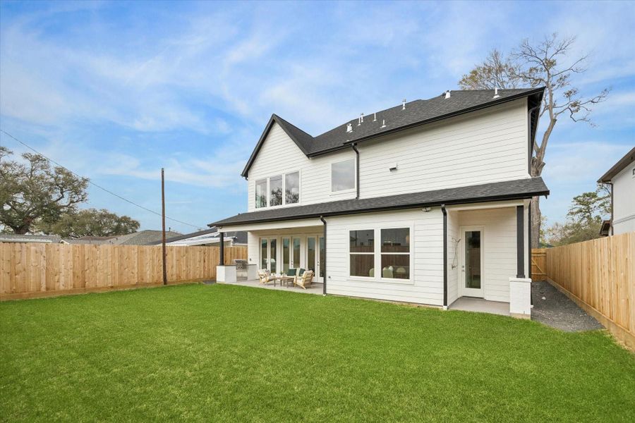 Private backyard with plenty of green space and large windows overlooking it from the main living areas.