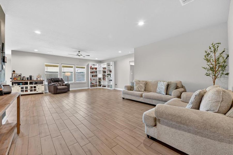 Expansive living area featuring wood-finish flooring, recessed lighting, and a ceiling fan