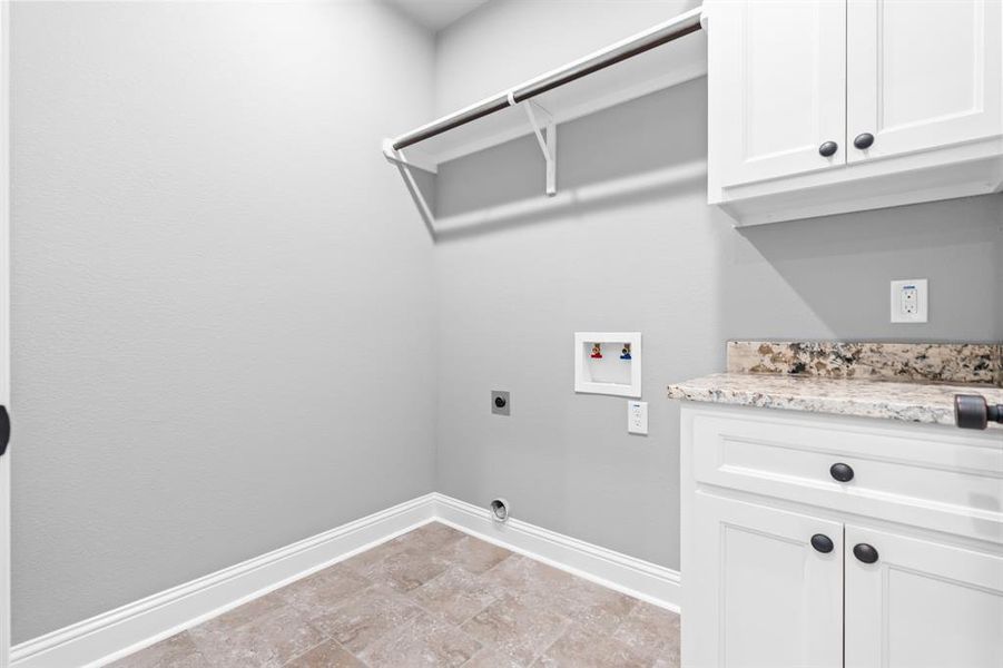 Washroom featuring cabinet space, electric dryer hookup, washer hookup, and baseboards Washroom featuring cabinet space, electric dryer hookup, washer hookup, and baseboards