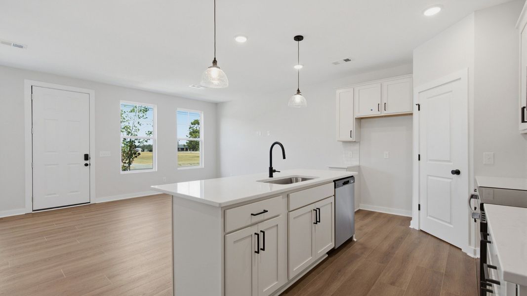 Kitchen island paired with sink and dishwasher with view of community