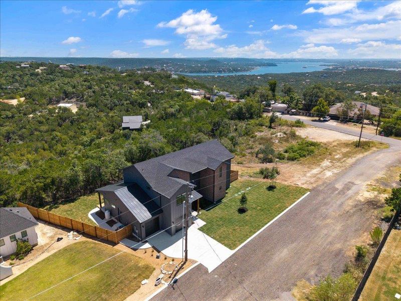 View of subject property with a large body of water and a heavily wooded area