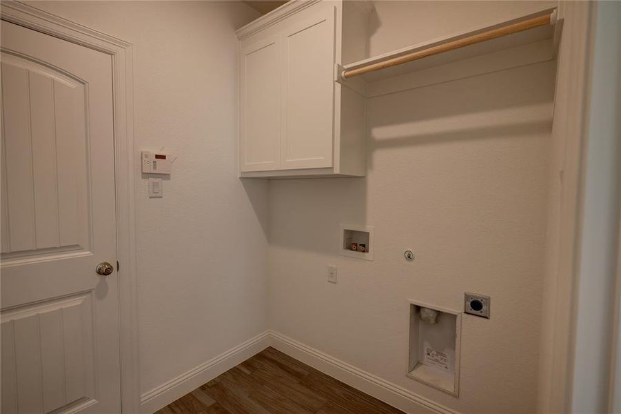 Laundry area with electric dryer hookup, cabinet space, hookup for a washing machine, dark wood finished floors, and gas dryer hookup Laundry area with electric dryer hookup, cabinet space, hookup for a washing machine, dark wood finished floors, and gas dryer hookup